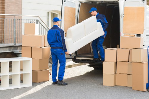 Removal team handling furniture in a townhouse or apartment